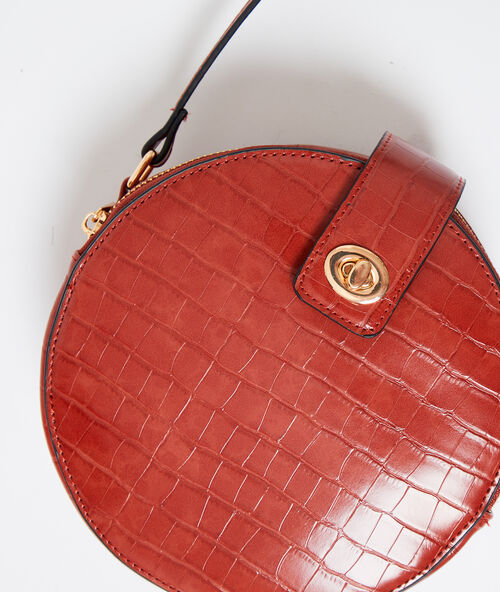 Round shaped bag in croc effect rust.